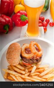 classic american hamburger sandwich with onion rings and french fries,glass of beer and fresh vegetables on background, MORE DELICIOUS FOOD ON PORTFOLIO