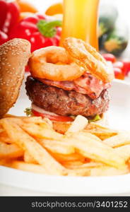 classic american hamburger sandwich with onion rings and french fries,glass of beer and fresh vegetables on background, MORE DELICIOUS FOOD ON PORTFOLIO