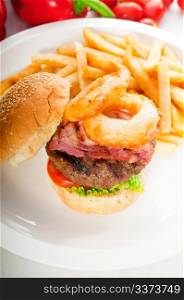 classic american hamburger sandwich with onion rings and french fries,with fresh vegetables on background, MORE DELICIOUS FOOD ON PORTFOLIO