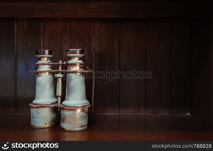 Classic Antique vintage retro brass binocular on wood floor isolated on dark wooden background with copy space