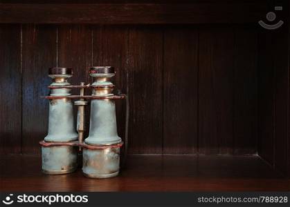 Classic Antique vintage retro brass binocular on wood floor isolated on dark wooden background with copy space
