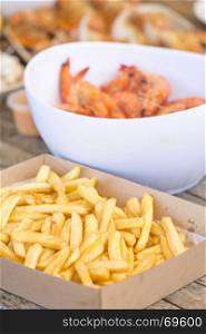 Classic Australian seafood lunch of french fries, shrimp, crab and more on outdoor table