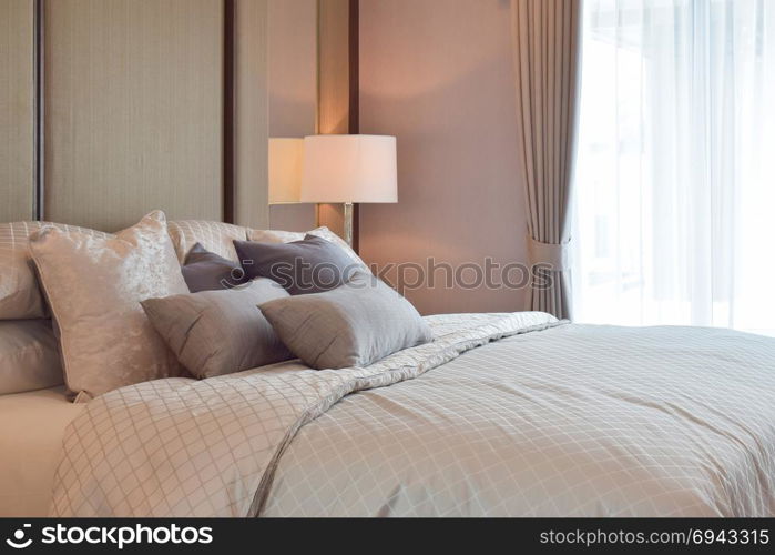 Classic bedroom interior with pillows and reading lamp on bedside table
