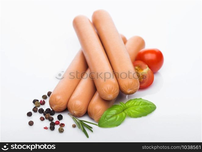 Classic boiled meat pork sausages with pepper and basil and cherry tomatoes on white. Snack for kids