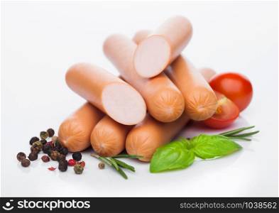 Classic boiled meat pork sausages with pepper and basil and cherry tomatoes on white. Snack for kids