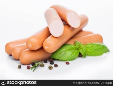 Classic boiled meat pork sausages with pepper and basil on white.