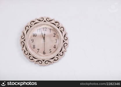 classic clock on a white wall background. almost twelve o&rsquo;clock. eleven o&rsquo;clock fifty-five minutes.. classic clock on a white wall background. almost twelve o&rsquo;clock. eleven o&rsquo;clock fifty-five minutes