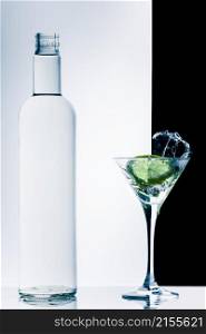 classic contemporary cocktail with splashes and bottle on black and white background. contemporary cocktail with splashes