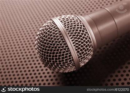 Classic dynamic microphone on background perforated. Toned
