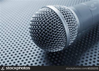Classic dynamic microphone on black background perforated