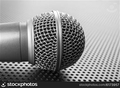 Classic dynamic microphone on black background perforated