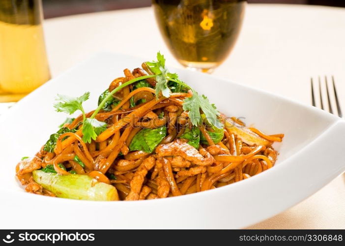 classic fresh chinese fried noodles with pork and vegetables and coriander on top