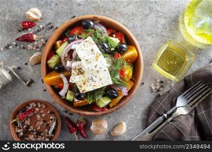 Classic Greek salad from tomatoes, cucumbers, red pepper, onion with olives, oregano and feta cheese.