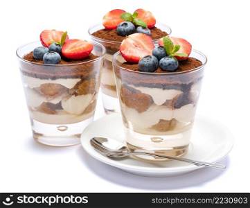 Classic italian tiramisu dessert with blueberries and strawberries in a glass isolated on a white background with clipping path. Classic tiramisu dessert with blueberries and strawberries in a glass isolated on a white background with clipping path