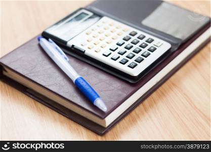 Classic leather notebook with pen and calculator, stock photo