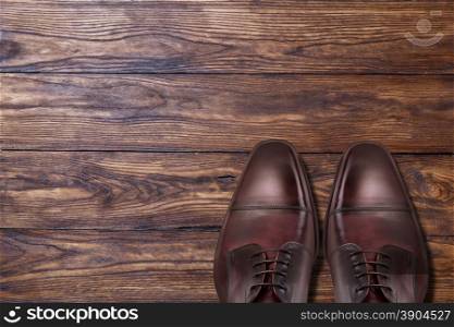 Classic male brown leather shoes on wooden background. Classic male brown leather shoes on wood