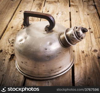 Classic old metal tea kettle in real vintage style on a wooden table