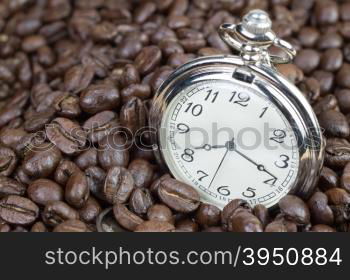 Classic pocket watch on coffee beans background&#xA;