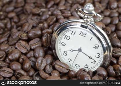 Classic pocket watch on coffee beans background&#xA;