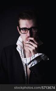 classic portrait of young man in glasses with cigarette on black background