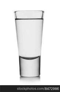 Classic shot glass with tequila or vodka on white.