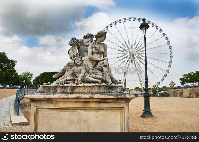 Classic statue with Ferris wheel in background, Tuileries Garden, Paris, France