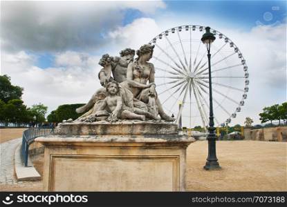 Classic statue with Ferris wheel in background, Tuileries Garden, Paris, France