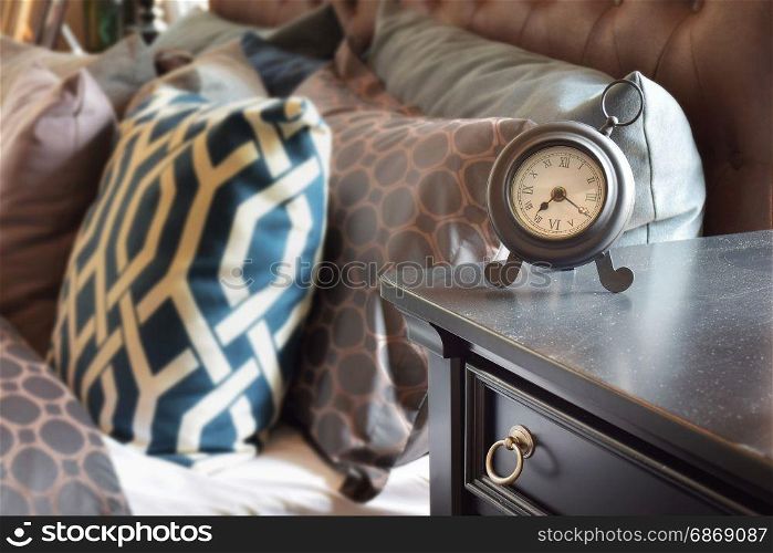 classic style alarm clock on wooden table in bedroom at home