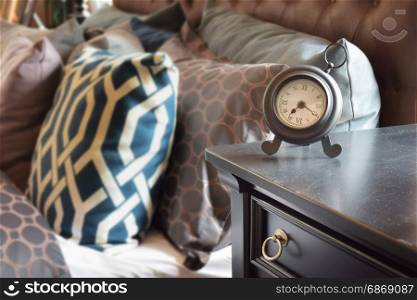classic style alarm clock on wooden table in bedroom at home