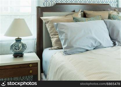 classic style bedroom with blue pillows and chinese lamp style on bedside table