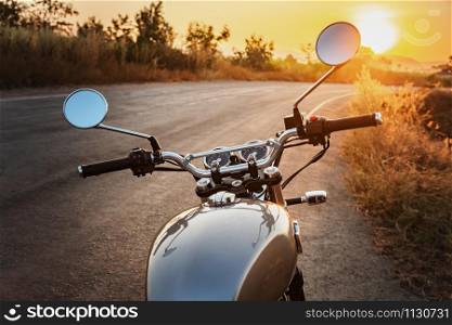 classic style motorcycle on road with sunset