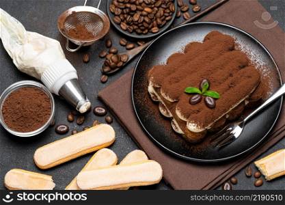 Classic tiramisu dessert and savoiardi cookies on ceramic plate on concrete background or table. Classic tiramisu dessert and savoiardi cookies on ceramic plate on concrete background