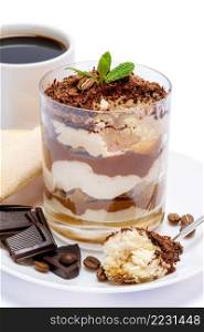 Classic tiramisu dessert in a glass, cup of coffee and pieces of chocolate on white background with clipping path embedded. Classic tiramisu dessert in a glass, cup of coffee and pieces of chocolate on white background with clipping path