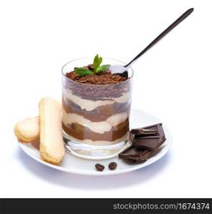 Classic tiramisu dessert in a glass cup on the plate and pieces of chocolate on white background with clipping path embedded. Classic tiramisu dessert in a glass cup on the plate and pieces of chocolate on white background with clipping path