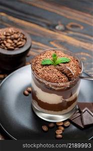 Classic tiramisu dessert in a glass cup on wooden background or table. Classic tiramisu dessert in a glass cup on wooden background