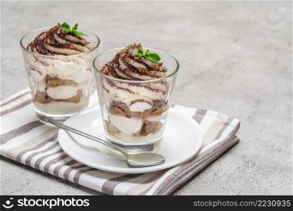 Classic tiramisu dessert in a glass on concrete background or table. Classic tiramisu dessert in a glass on concrete background