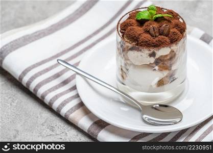 Classic tiramisu dessert in a glass on concrete background or table. Classic tiramisu dessert in a glass on concrete background