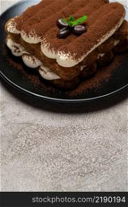 Classic tiramisu dessert on ceramic plate on light grey concrete background or table. Classic tiramisu dessert on ceramic plate on light grey concrete background