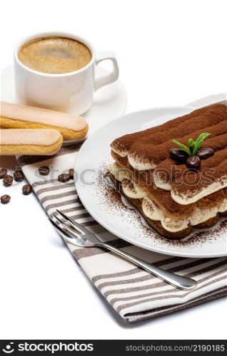 Classic tiramisu dessert on ceramic plate, savoiardi cookies and cup of coffee isolated on white background with clipping path embedded. Classic tiramisu dessert on ceramic plate, savoiardi cookies and cup of coffee isolated on white background with clipping path