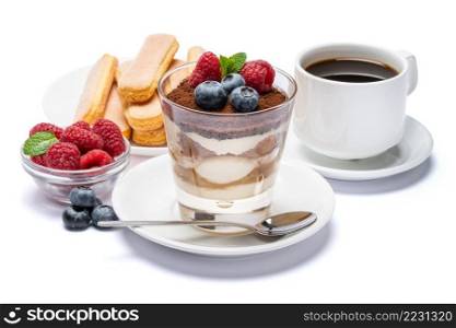 Classic tiramisu dessert with blueberries and raspberries in a glass cup, savoiardi cookies and espresso coffee on white background with clipping path embeeded. Classic tiramisu dessert with blueberries and raspberries in a glass cup, savoiardi cookies and espresso coffee on white background with clipping path