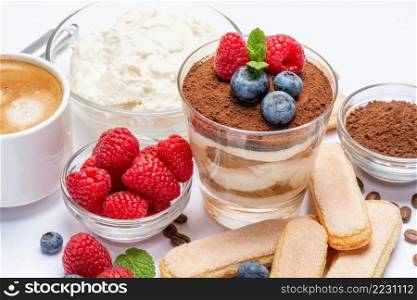 Classic tiramisu dessert with blueberries and raspberries in a glass, savoiardi and mascarpone cheese isolated on a white background. Classic tiramisu dessert with blueberries and raspberries in a glass, savoiardi and mascarpone cheese isolated on a white