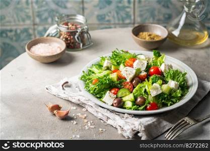 Classic vegetable salad with fresh olives, tomatoes, cucumbers, greek cheese feta and olive oil on gray background.. Classic vegetable salad
