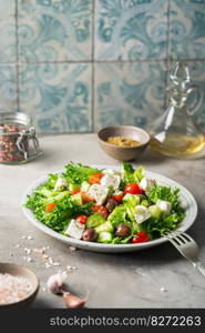 Classic vegetable salad with fresh olives, tomatoes, cucumbers, greek cheese feta and olive oil on gray background.. Classic vegetable salad