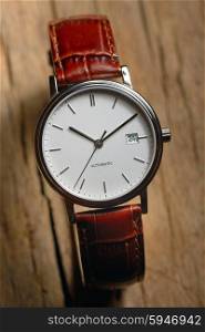 Classic wrist watch over wooden background