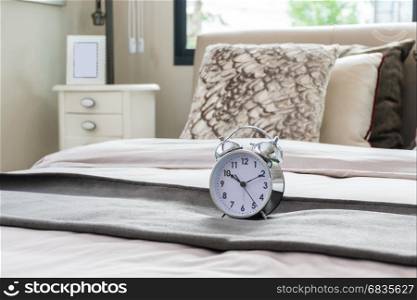 classical alarm clock on bed