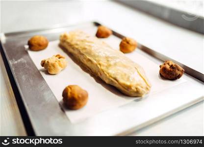 Classical apple strudel on metal baking sheet closeup, uncooked bakery, nobody. Homemade sweet dessert