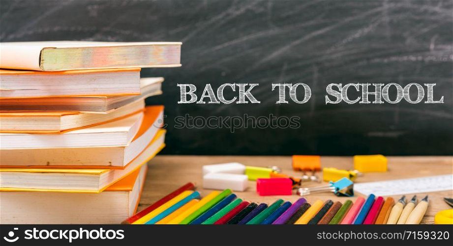 Classroom, with stack books on table have blackboard and chalkboard on background, back to school concept