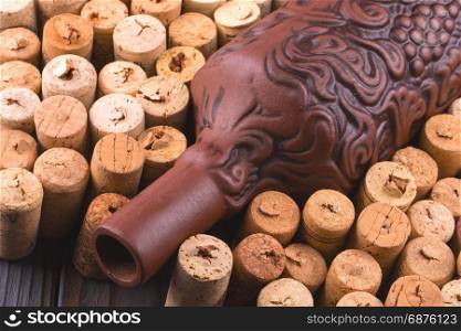 Clay bottle of wine and cork on a dark wooden table