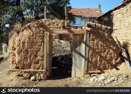 Clay fence and wooden door in turkish village, Turkey