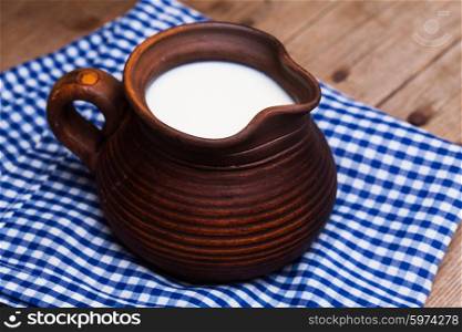 Clay jug full of milk in a rustic style. Healthy drink